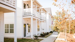 A row of white buildings with balconies, a covered walkway, and a well-maintained lawn. - Artist Retreat | Near Downtown, Stadium & UGA (Athens)