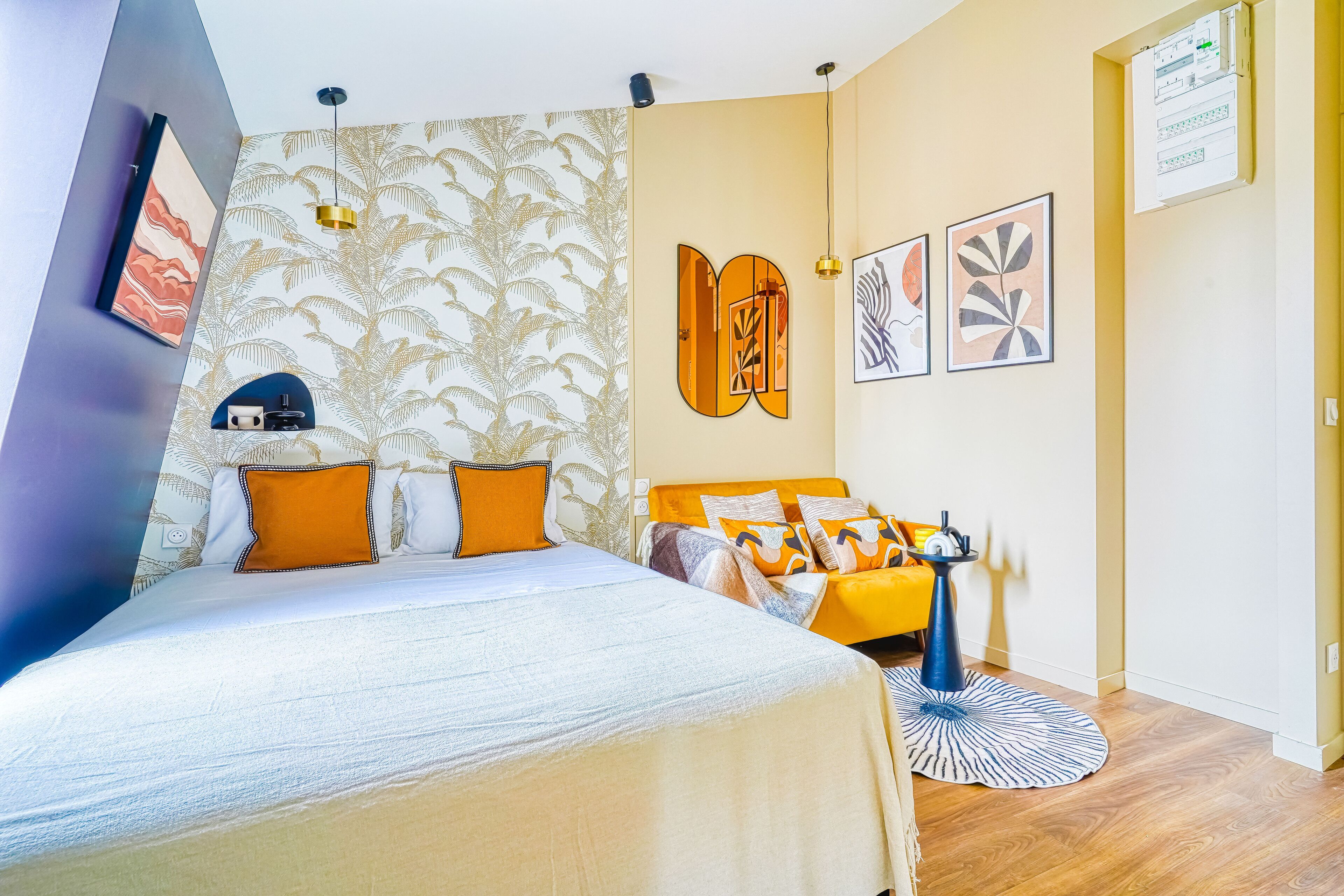A modern bedroom with a bed, a sofa, and a small table.