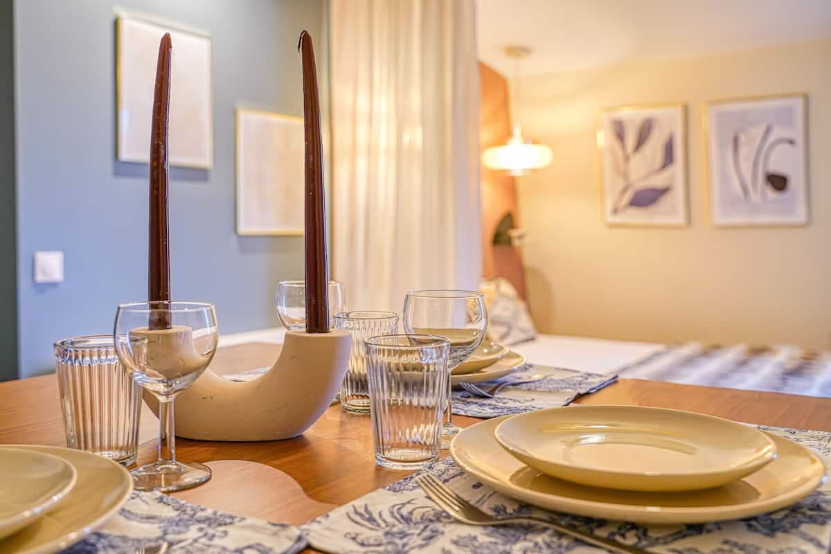A dining table set with plates, glasses, and a bowl.