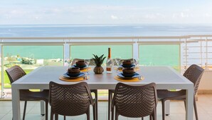 A dining table set for four with a view of the sea. - Luxury Seafront 3BR w/Pool by ArcoCollection (Sliema)
