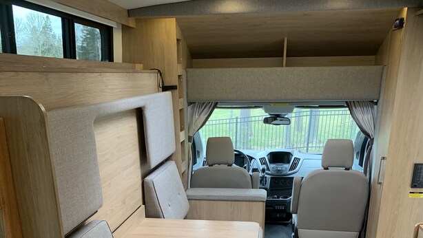 A compact RV interior with a kitchenette, seating area, and a view of the outside. - 2020 Leisure Travel Rv Wonder at Boothbay Harbor, Maine!   (Boothbay)