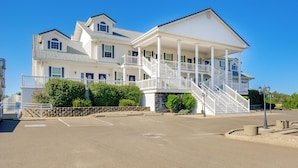 A large, two-story building with a covered porch and a staircase leading to the upper level. - Ocean Shores Condo w/ Private Tub < 1 Mi to Beach! (Ocean Shores)