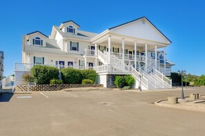 A large, two-story building with a covered porch and a staircase leading to the upper level. - Ocean Shores Condo w/ Private Tub < 1 Mi to Beach! (Ocean Shores)