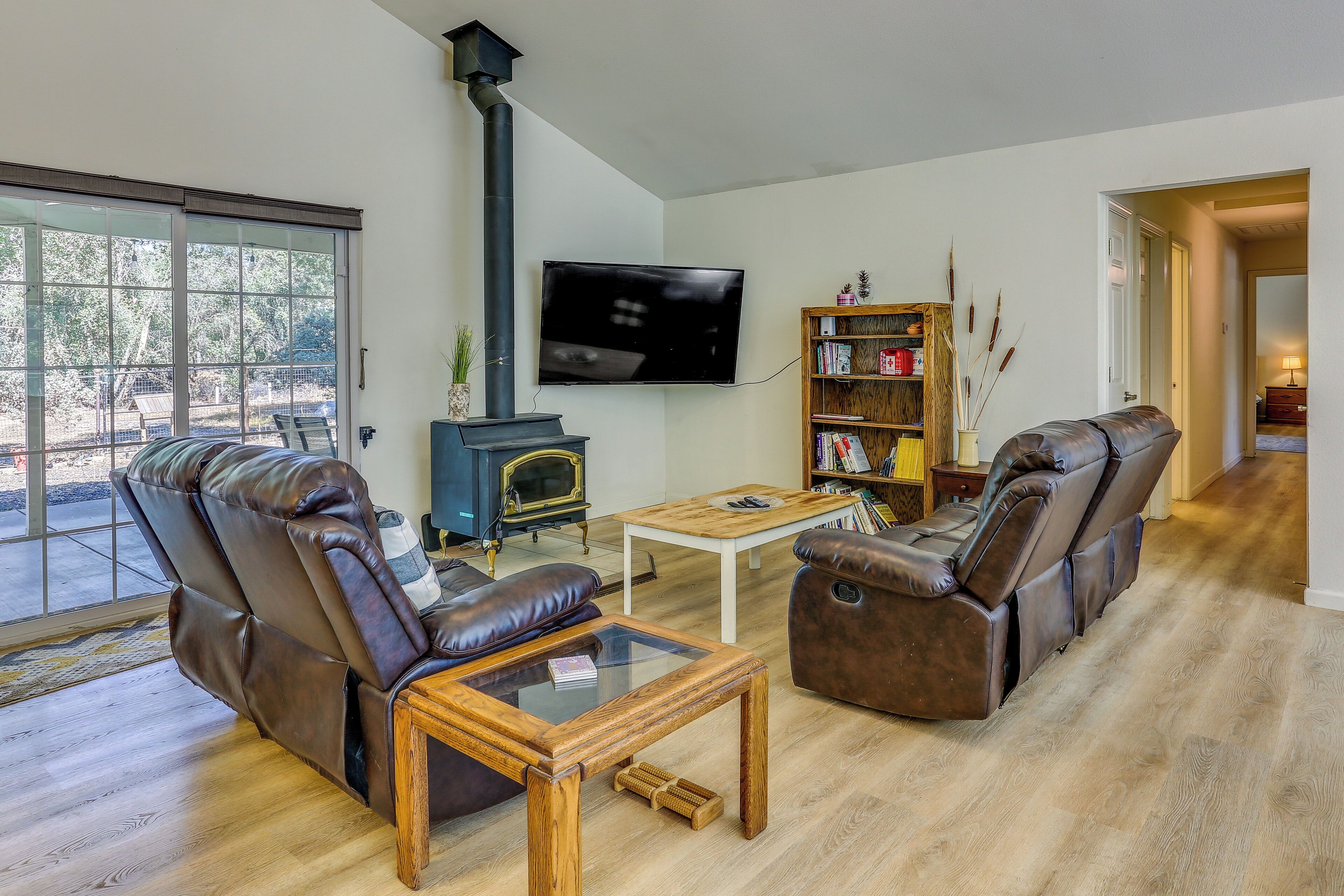 A living room with leather sofas, a wooden coffee table, a fireplace, and a bookshelf.