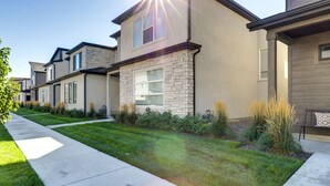 A row of modern townhouses with a well-maintained lawn and a concrete pathway. - Inviting American Fork Home With Community Pool! (American Fork)