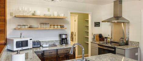 A kitchen with granite countertops, stainless steel appliances, and wooden cabinets.