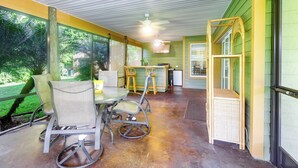 A covered patio with a table and chairs, a ceiling fan, and a view of greenery outside. - Pet-friendly Fort Pierce Home w/ Screened Porch! (Fort Pierce)