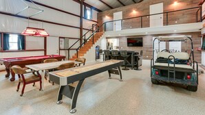 A spacious indoor area with a pool table, billiards, and a shuffleboard table. - Lake Texoma Vacation Rental: 1 Mi to Boat Ramp! (Pottsboro)