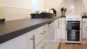 Een moderne keuken met witte kasten, een zwart aanrechtblad en een ingebouwde oven.