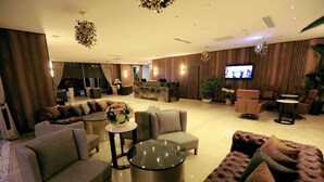 Una sala de estar moderna con un sofá, sillones, una mesa de centro y un televisor.