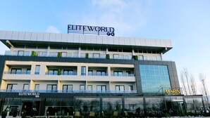Un edificio moderno con un letrero que dice "ELITEWORLD GO" y "ELITE MARIN RESTAURANT" en la planta baja.