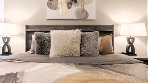 A bedroom with a large bed, fluffy pillows, and two bedside lamps. - Fun in the Sun! Pool, Fenced Yard, Ping Pong, BBQ (Naples)