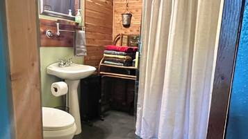 Ein kleines Badezimmer mit Toilette, Waschbecken und einer Duschvorhang.