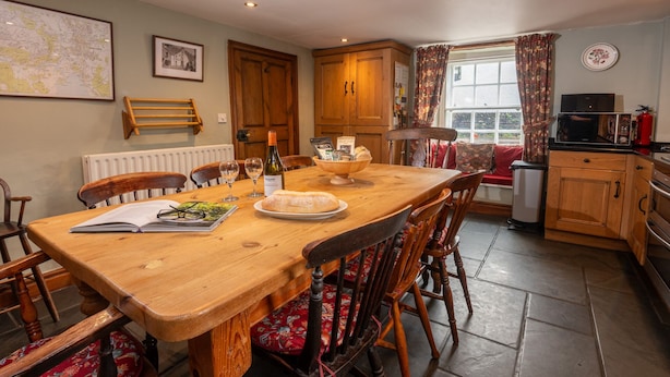 Una cocina acogedora con una mesa de madera, sillas y un comedor.