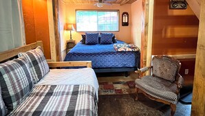 Ein gemütliches Schlafzimmer mit einem Bett, einem Sessel, einem Nachttisch und einem Fenster.