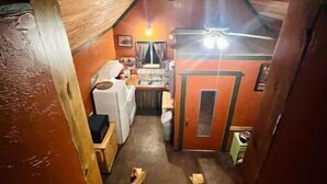 Eine schmale Holztreppe führt zu einer kleinen Küche mit einfachen Annehmlichkeiten.