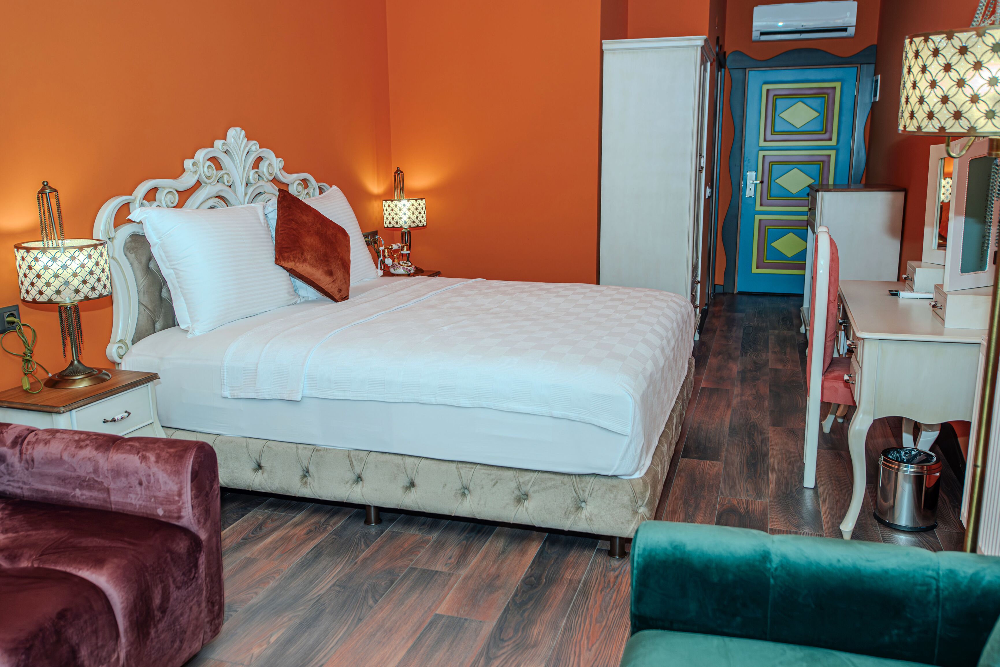 Une chambre à coucher avec un lit, des tables de chevet, une commode et un miroir.