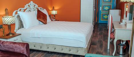 Un dormitorio con cama, mesitas de noche, cómoda y espejo.