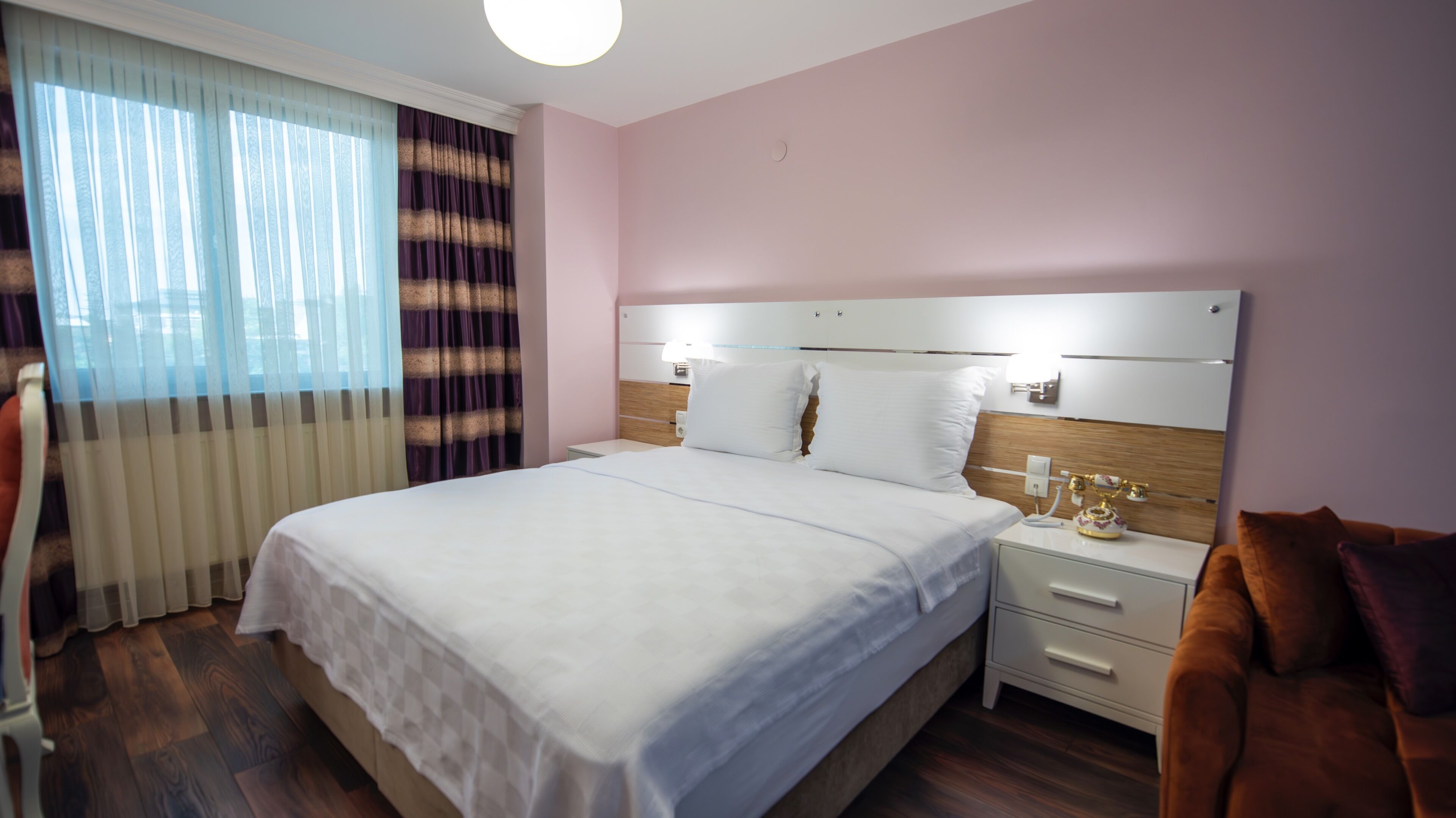 Una habitación de hotel con una cama grande, mesitas de noche, una lámpara y un adorno.