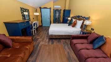 Un dormitorio con cama, escritorio, silla y dos sofás.