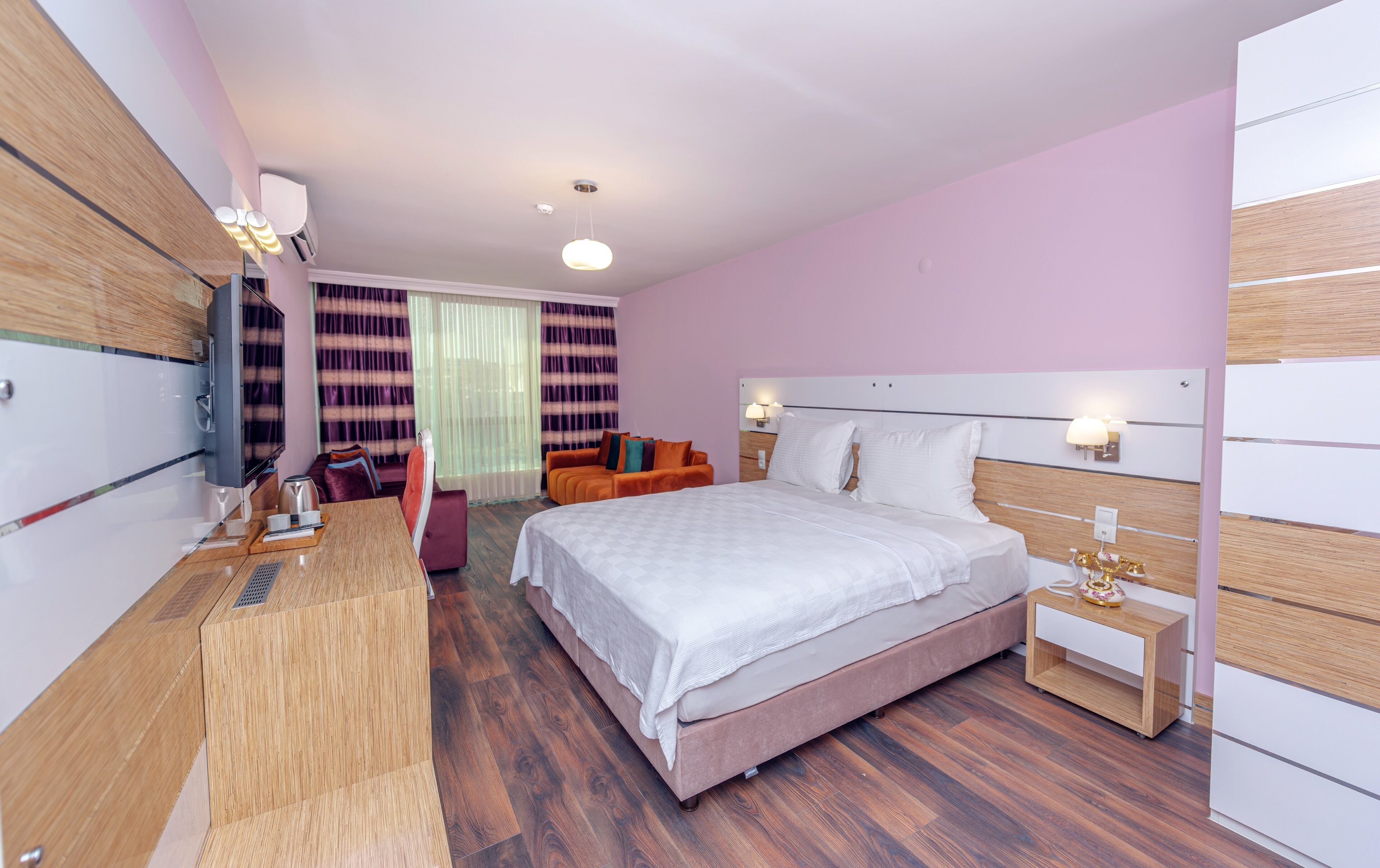 Une chambre d’hôtel moderne, dotée d’un grand lit, d’un bureau, d’une chaise et d’un canapé.
