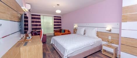 Une chambre d’hôtel moderne, dotée d’un grand lit, d’un bureau, d’une chaise et d’un canapé.