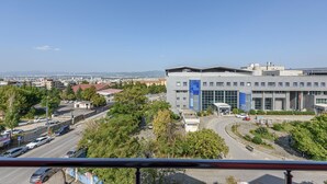 A modern building with a large glass facade, surrounded by greenery and a clear sky. - TOK EPİK HOTEL (Bursa)