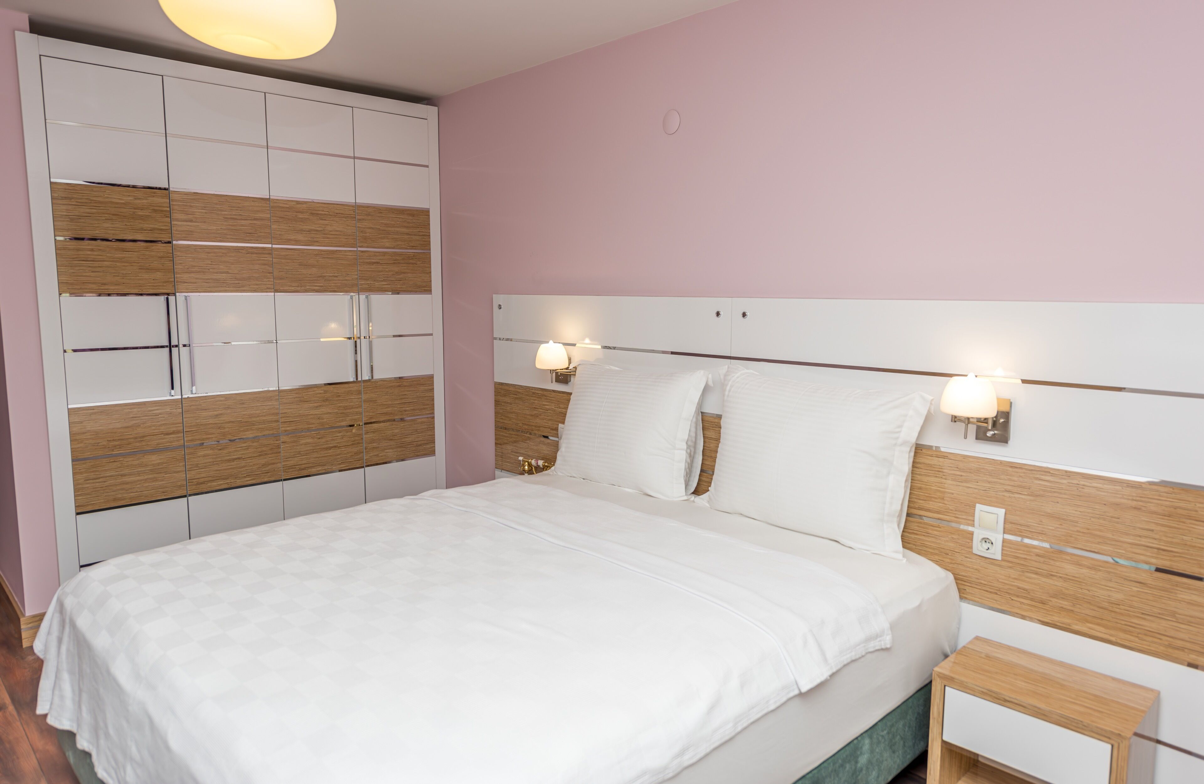 Une chambre à coucher avec un lit, des tables de chevet et une armoire.