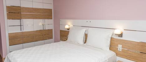 Une chambre à coucher avec un lit, des tables de chevet et une armoire.