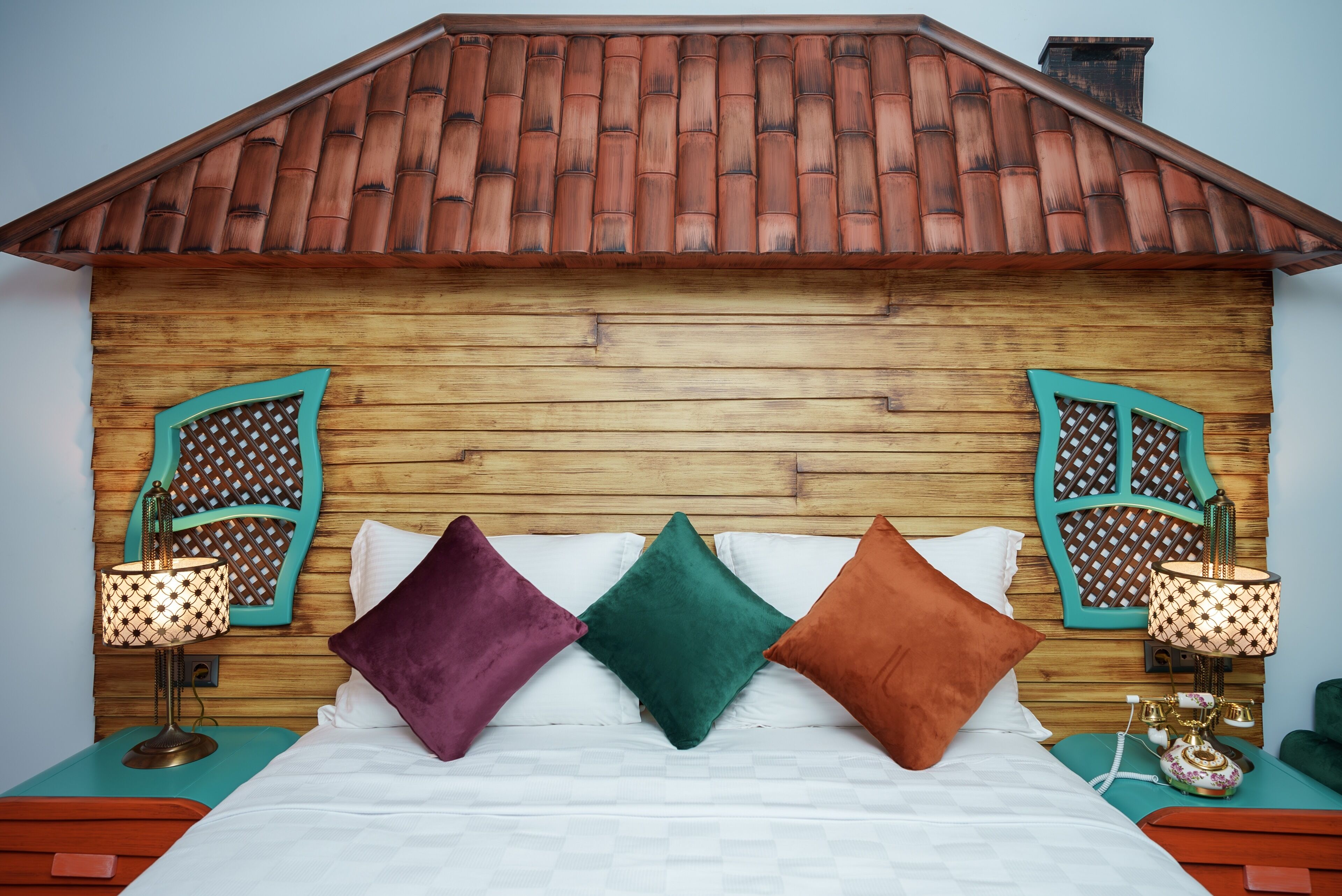 A bed with a wooden headboard, two nightstands, and decorative lamps.