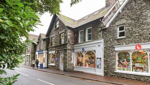 A street with stone buildings, one with a sign for 'Peter Rabbit and Friends'. - Riverbank (Ambleside)