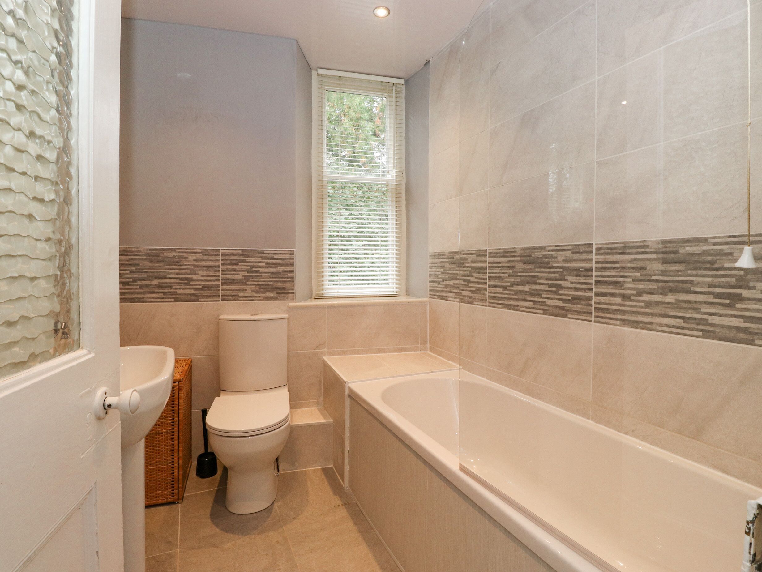 A bathroom with a toilet, sink, and bathtub.