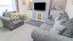 A living room with grey sofas, a television, and a fireplace. - Bay Cottage Morecambe Beach 4 Berth 2 Bedrooms (Morecambe)