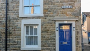 A stone building with a blue door and a window with white trim. - Bay Cottage Morecambe Beach 4 Berth 2 Bedrooms (Morecambe)