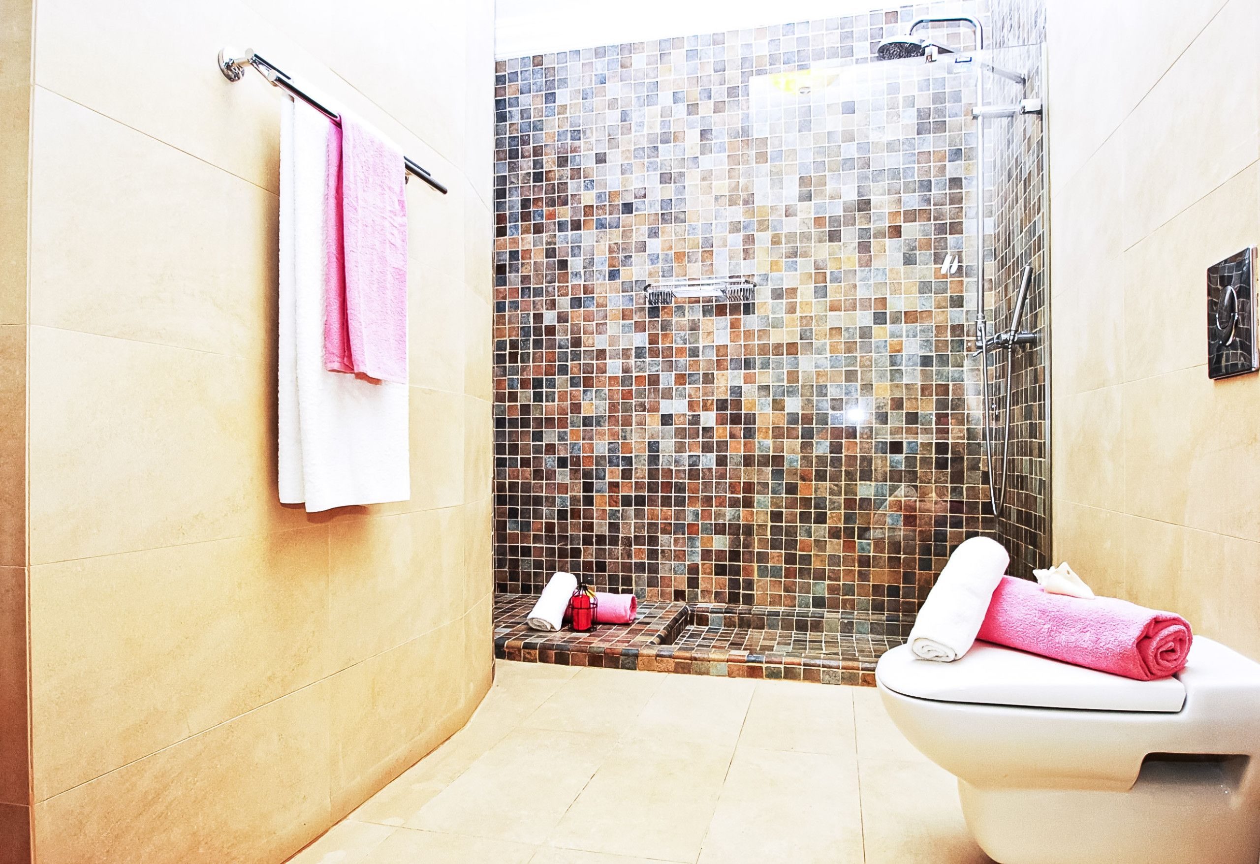A bathroom with a shower, tiled walls, and a toilet.