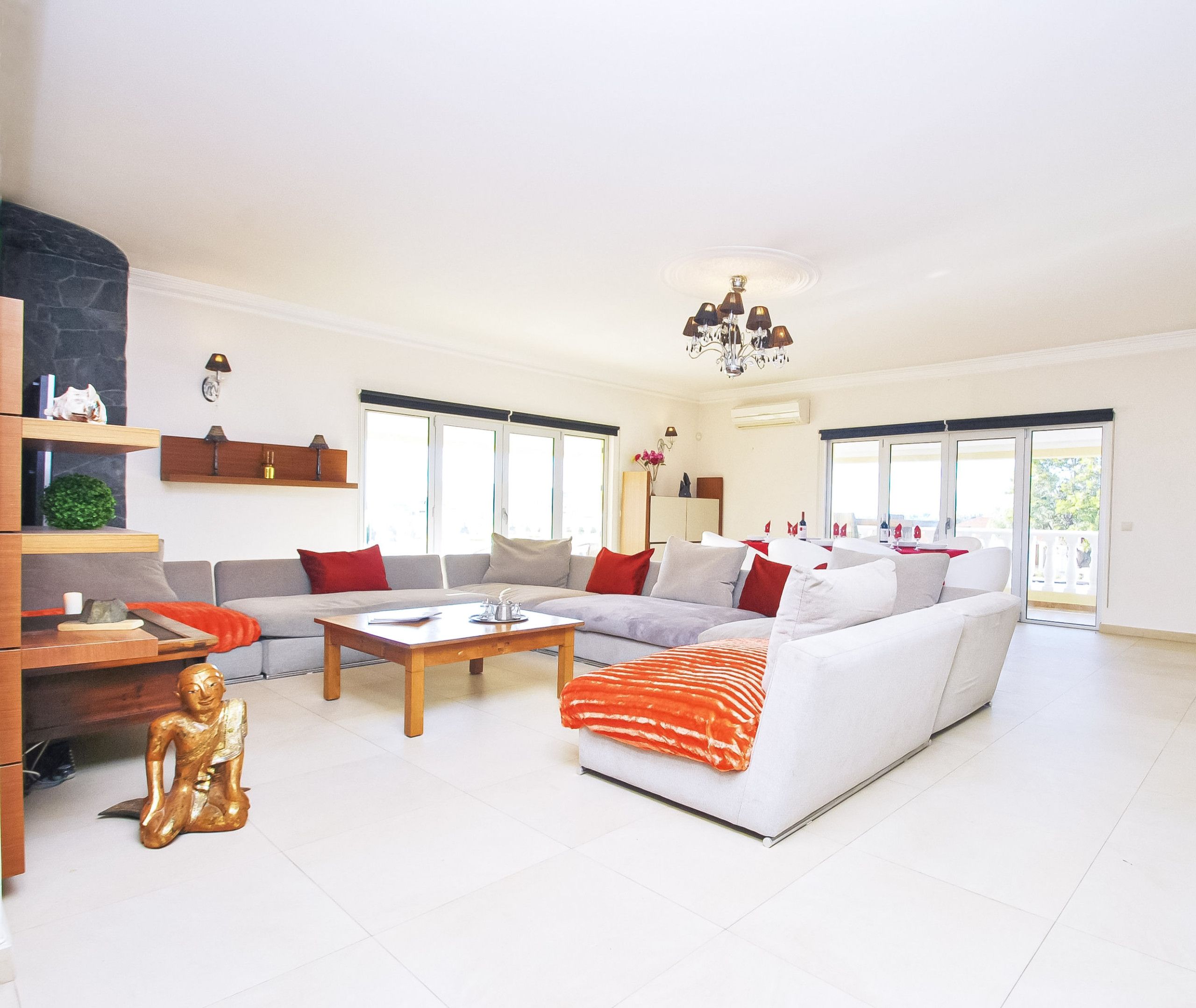 A spacious living room with a large sofa set, a coffee table, and a fireplace.