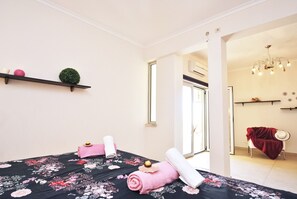 A hotel room with a bed, a small shelf with decorative items, a window, and a door leading to another room. - Villa w/ BBQ and Pool in Albufeira (Albufeira)