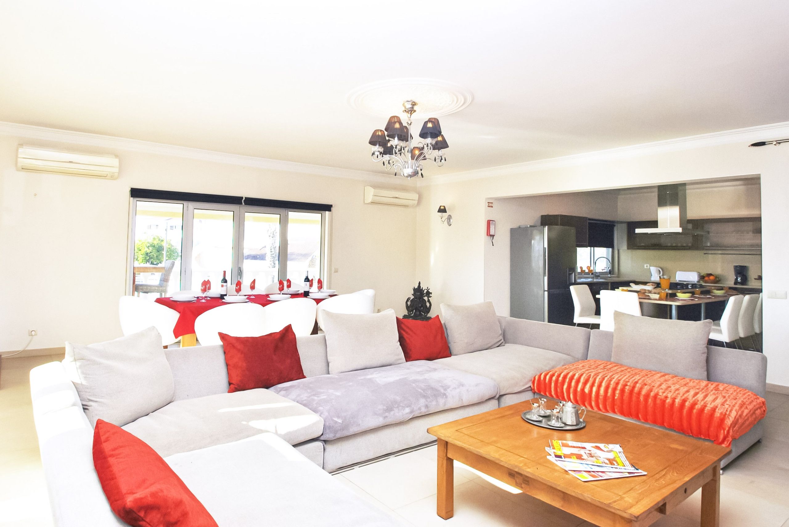 A modern living room with a sofa, a coffee table, and a dining area with a table set for four.