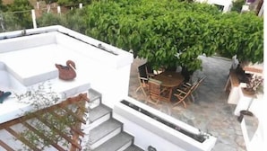 Une terrasse sur le toit comprenant un espace repas, un escalier et un petit jardin.