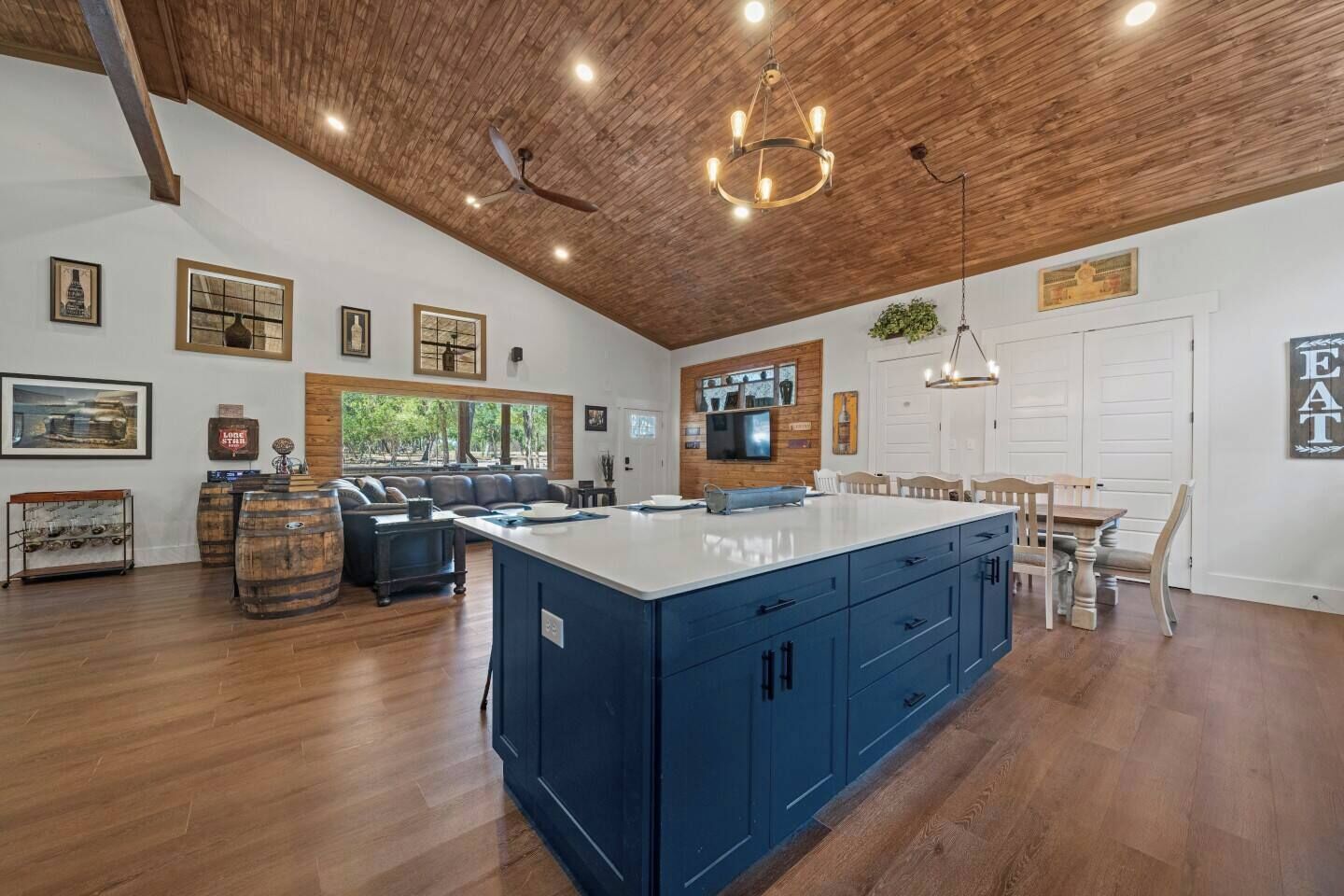 Een ruime keuken met een groot kookeiland, houten plafond en moderne apparatuur.