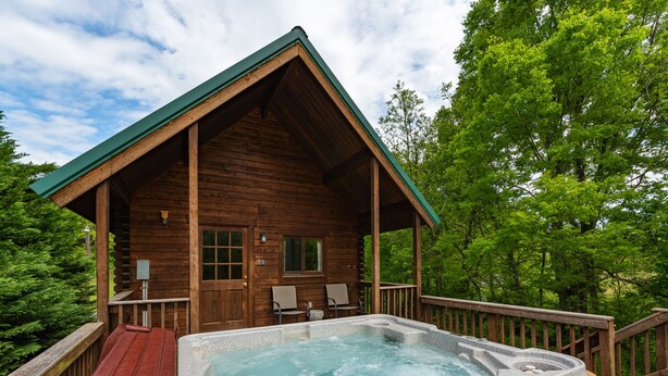 A wooden cabin with a hot tub and deck chairs. - Riverfront! Mountain views 4 Miles to Luray Caverns  hot tub! at Line cabin (Luray)