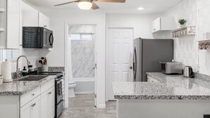 A modern kitchen with white cabinetry, granite countertops, a built-in microwave, a refrigerator, and a ceiling fan. - 5 min to Old Town-Sleeps 12-Heated Pool-King Bed-Ping Pong-Fire Pit (Scottsdale)