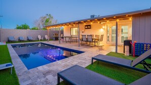 A backyard with a swimming pool, patio furniture, and a covered seating area. - 5 min to Old Town-Sleeps 12-Heated Pool-King Bed-Ping Pong-Fire Pit (Scottsdale)