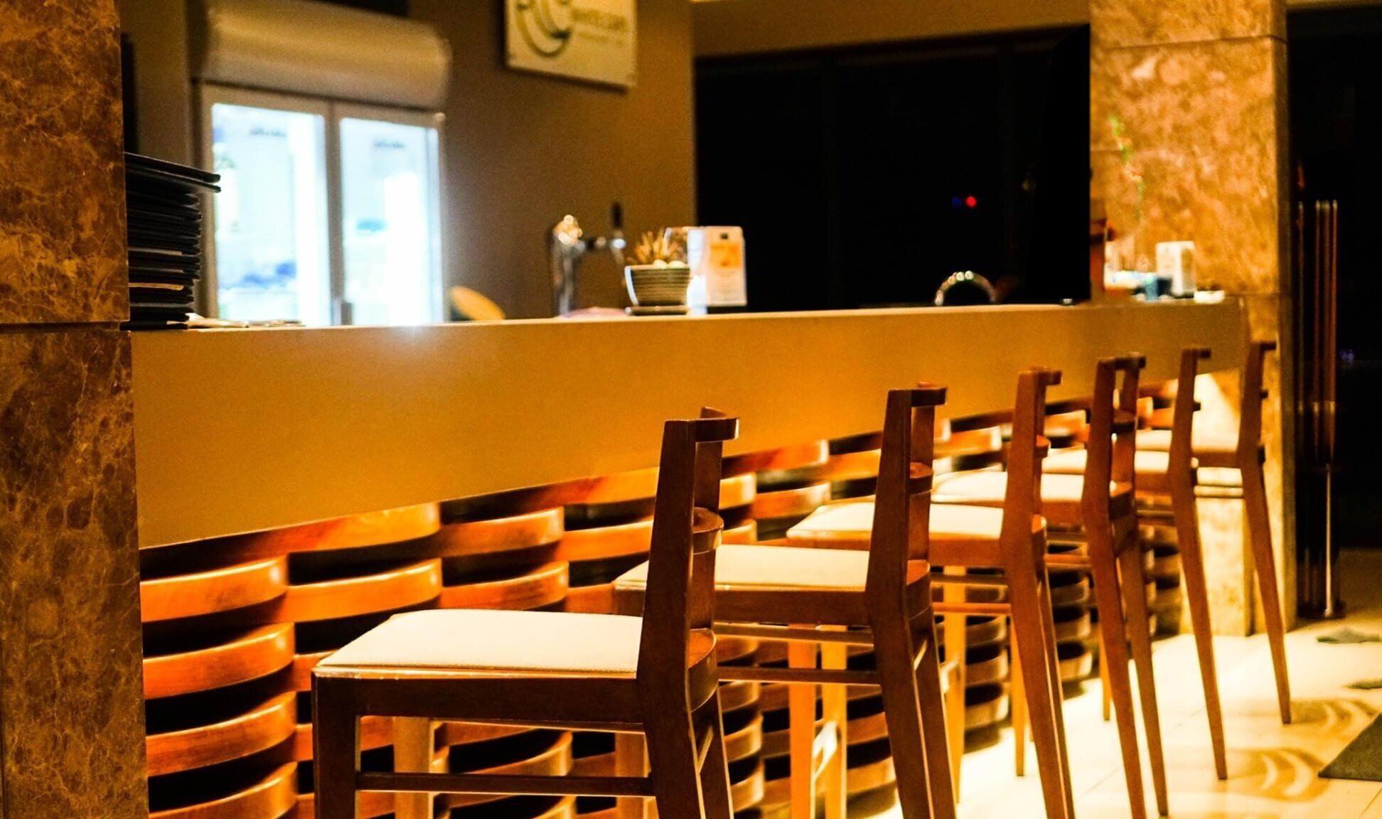 A bar area with wooden chairs and a counter.