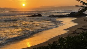 A beach with a sunset, waves, and some rocks. - Beautiful Caribbean Ocean View Gem ! Newly remodeled apartment.  (Luquillo)