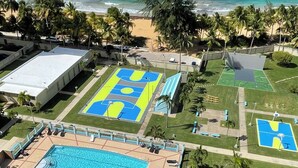 A resort with a large pool, multiple sports courts, and a beach view. - Beautiful Caribbean Ocean View Gem ! Newly remodeled apartment.  (Luquillo)