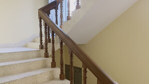 A staircase with wooden balusters and a handrail, leading to an upper floor. - Hotel Blue Sky (Dhaka)