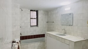 A bathroom with a toilet, sink, and a window. - Hotel Blue Sky (Dhaka)