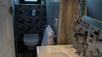 Ein Badezimmer mit einem weißen Waschbecken, einem Spiegel und einer Toilette.