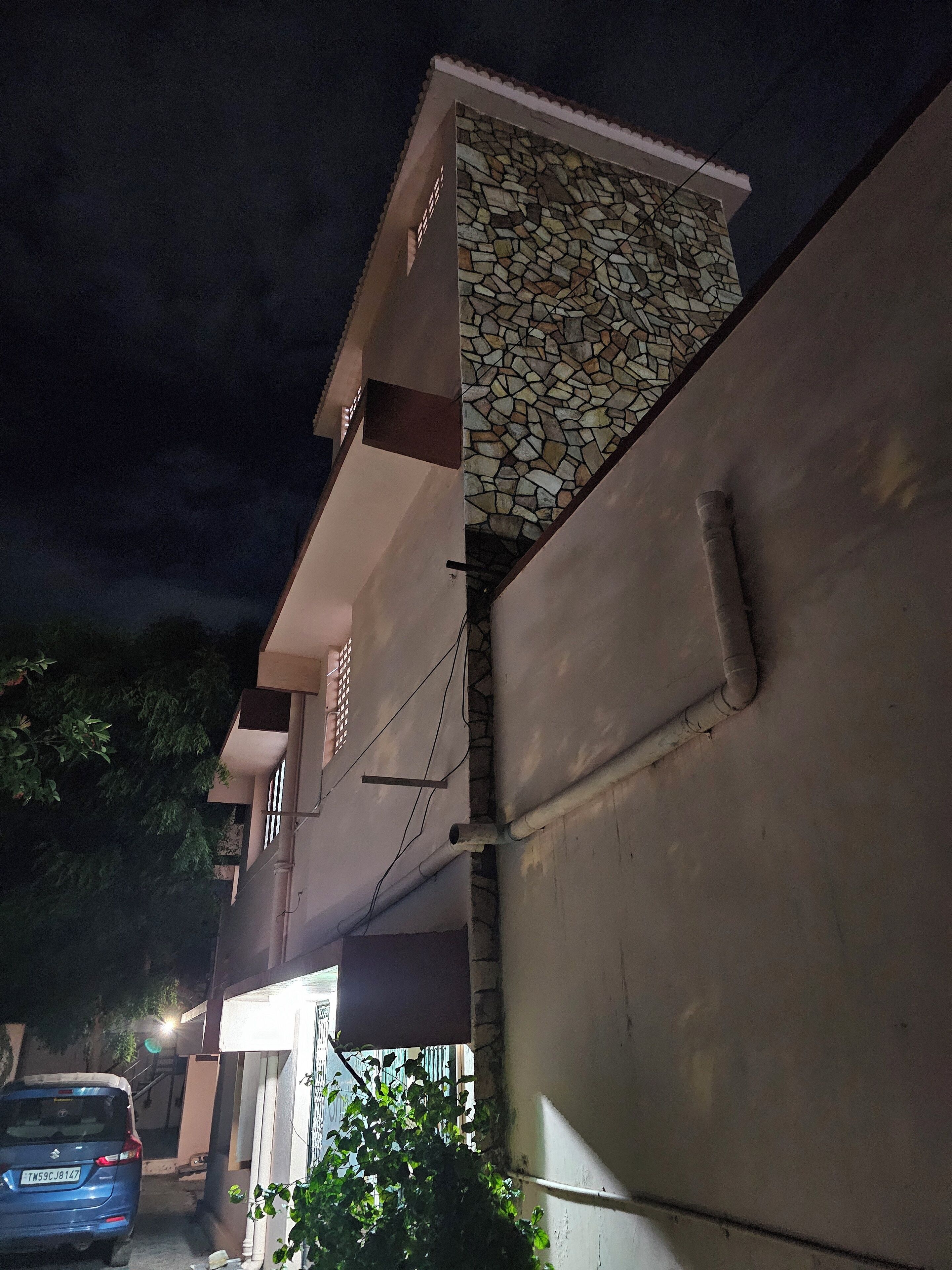 A building with a stone facade and a car parked in front.